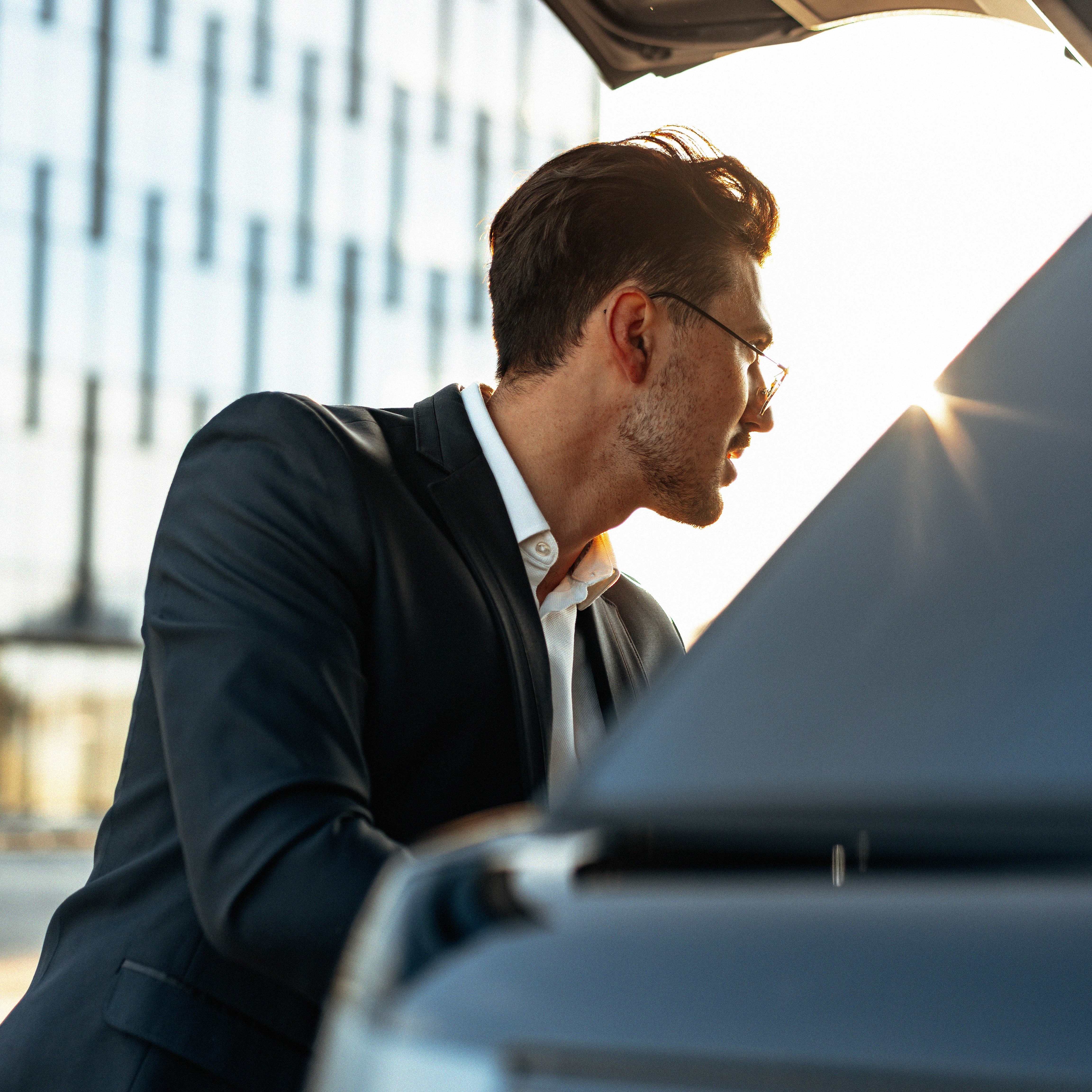 En man vid bakluckan på en bil. Foto.