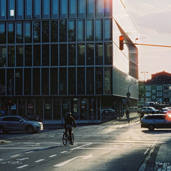 Cykel vid rödljus framför en kontorsbyggnad i solnedgången