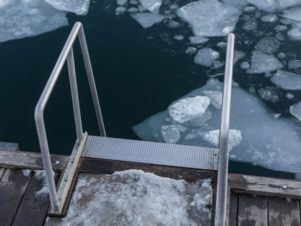 En stege som leder ner till isigt vatten.